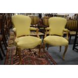 A PAIR OF CARVED GILTWOOD FRAMED AND UPHOLSTERED OPEN ARMCHAIRS.