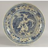 A CHINESE MING STYLE BLUE AND WHITE PLATTER decorated with dragons. 22ins deep.