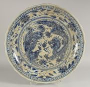 A CHINESE MING STYLE BLUE AND WHITE PLATTER decorated with dragons. 22ins deep.