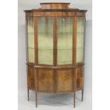 A GOOD EDWARDIAN MAHOGANY STANDING DISPLAY CABINET of serpentine outline, with a pair of glazed