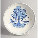 AN 18TH CENTURY DELFT BLUE AND WHITE CIRCULAR CHARGER decorated with flowers. 14ins diameter (AF)