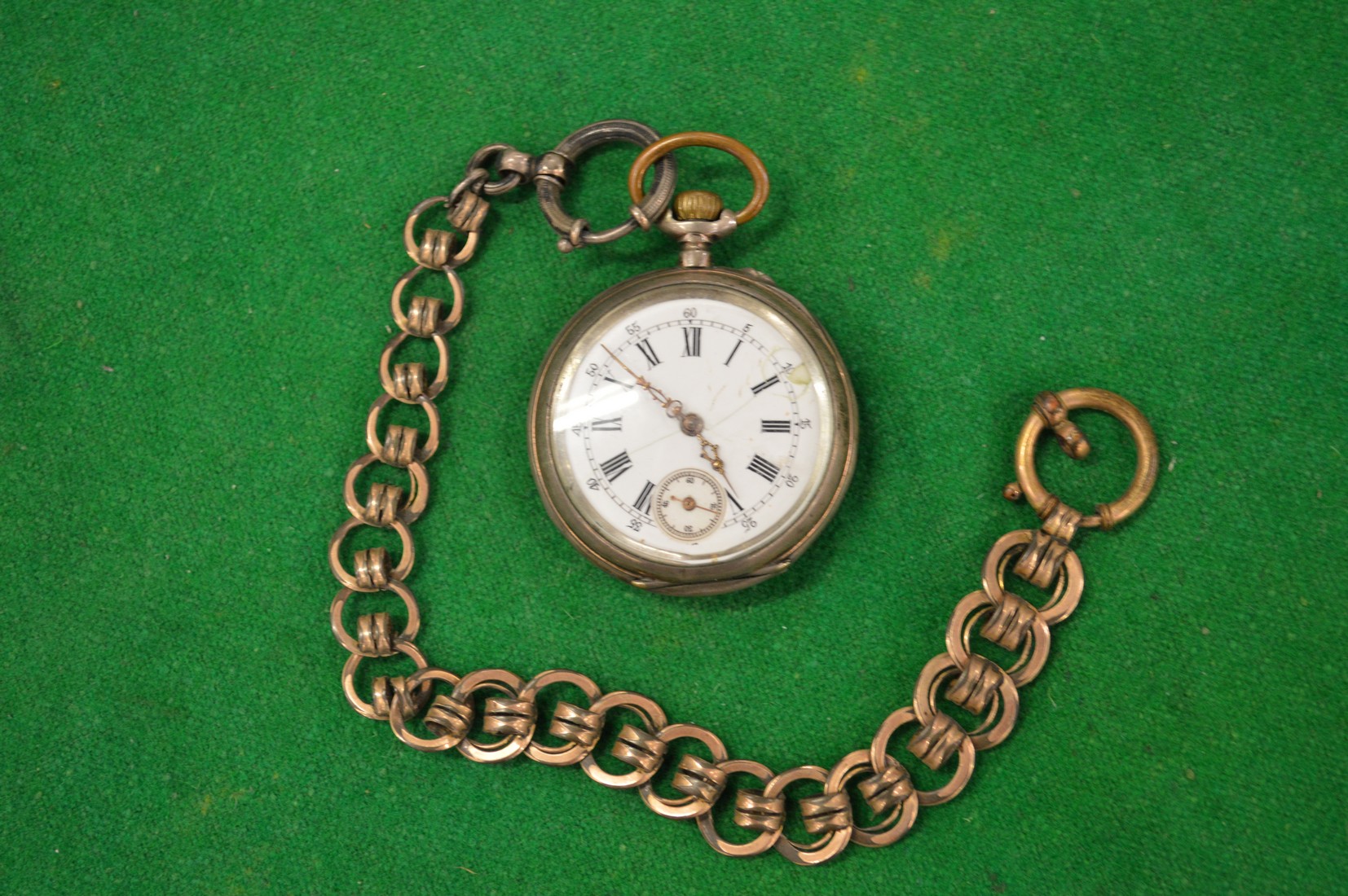 A pocket watch with gilt metal chain.