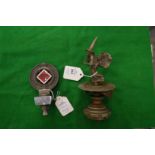 An unusual cast metal car mascot modelled as a witch with a revolving numbered base together with an