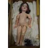 A good porcelain headed doll with articulated limbs.