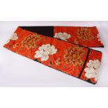 A FINE QUALITY JAPANESE EMBROIDERED SILK FUKURO OBI TIE, with a black and red ground with floral and