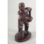 A CARVED HARDWOOD FIGURE OF A BOY carrying a satchel upon an oval shape base, possibly Republican,