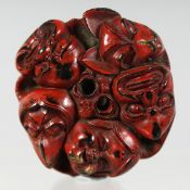 A JAPANESE CARVED LACQUERED WOODEN NETSUKE, carved as multiple Noh masks. 4cm diameter