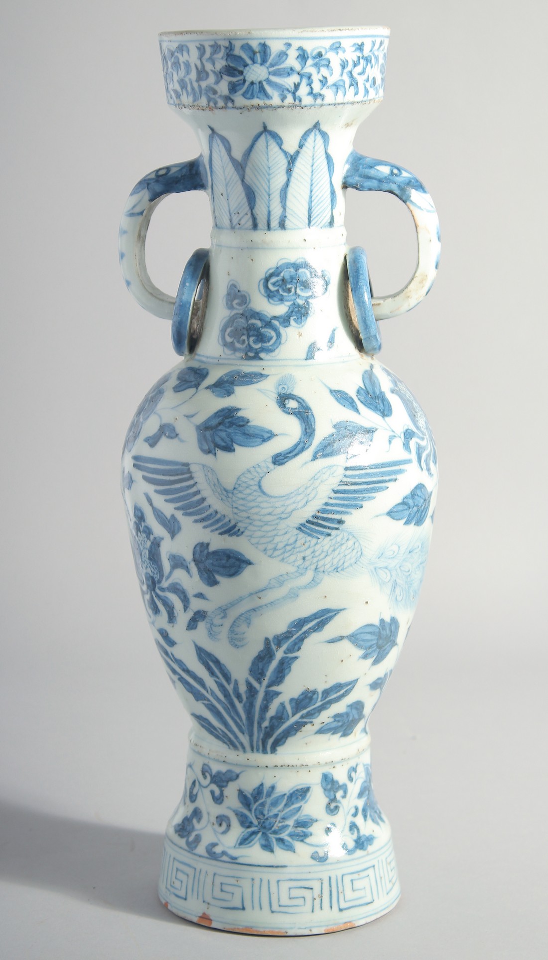 A CHINESE YUAN STYLE BLUE AND WHITE GLAZED POTTERY TWIN HANDLE VASE, painted with birds and flora,