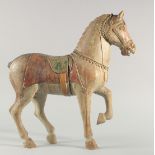 A LARGE 19TH CENTURY INDIAN CARVED WOODEN MODEL OF A HORSE, with painted body and saddle, 53cm long,