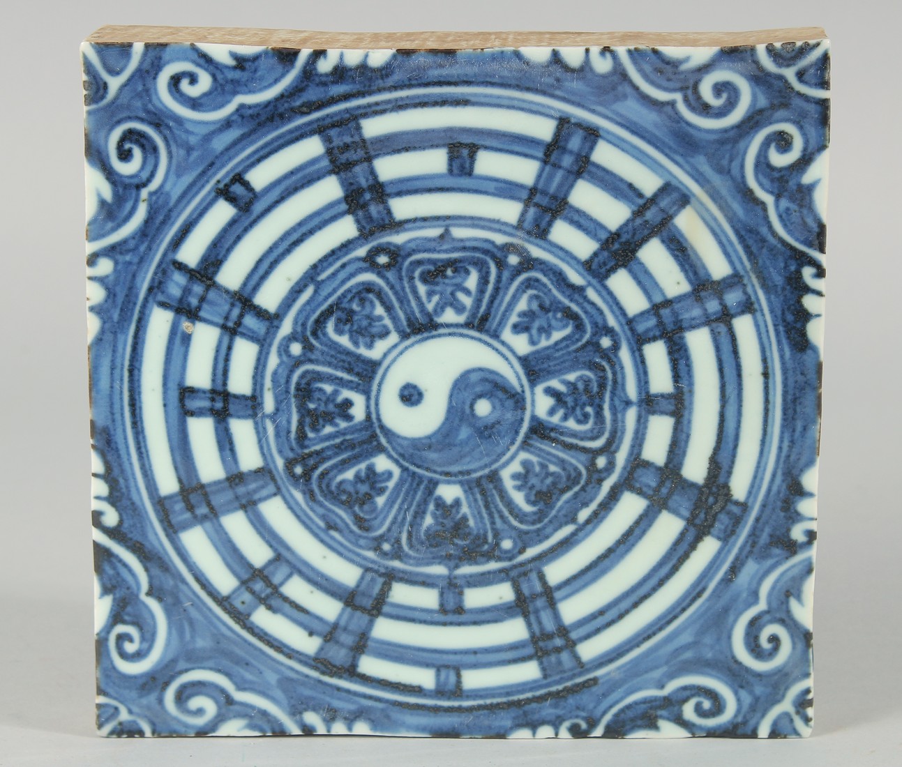 A CHINESE BLUE AND WHITE GLAZE TEMPLE TILE, 19cm x 19.5cm.