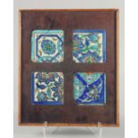 A SET OF FOUR FRAMED 18TH CENTURY IZNIK GLAZED POTTERY TILES, each with different foliate motifs