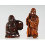 TWO JAPANESE CARVED WOODEN NETSUKES, one of a figure holding a staff, 5cm, the other of a seated