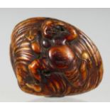 A JAPANESE CARVED WOODEN NETSUKE, in the shape of a shell with figural carving. 5cm wide