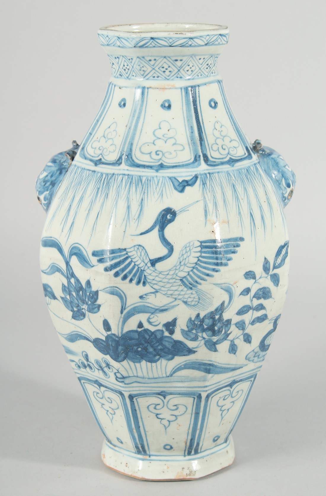 A CHINESE OCTAGONAL BLUE AND WHITE TWIN HANDLE VASE, with moulded lion heads as handles, the body