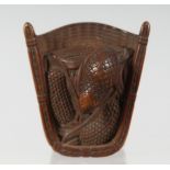 A JAPANESE CARVED WOODEN NETSUKE of a quail stood in a basket, 5cm wide.