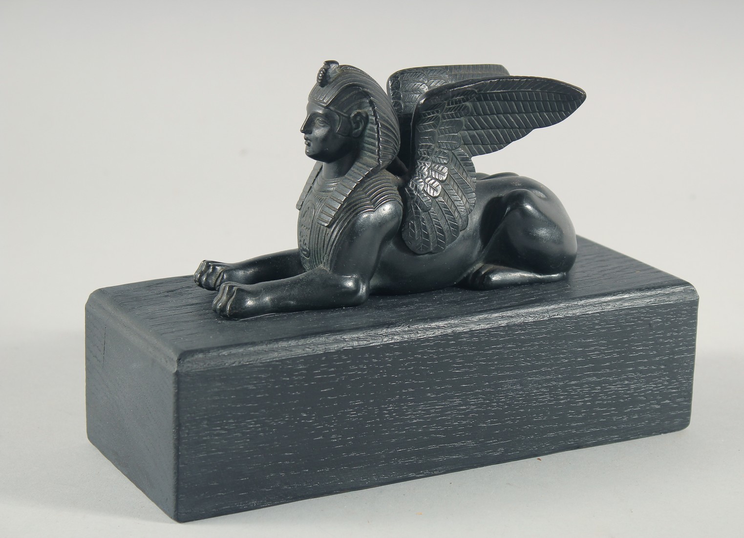 AN EGYPTIAN BRONZE SPHYNX, 6ins long on a wooden base. - Image 3 of 4