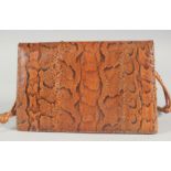 A 1940's - 1950's SNAKESKIN HANDBAG with fold over flap, leather fitted interior and long entwined