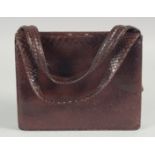 A 1940's - 1950's BROWN SNAKESKIN HANDBAG with fitted leather interior and two handles. 7.5ins deep,