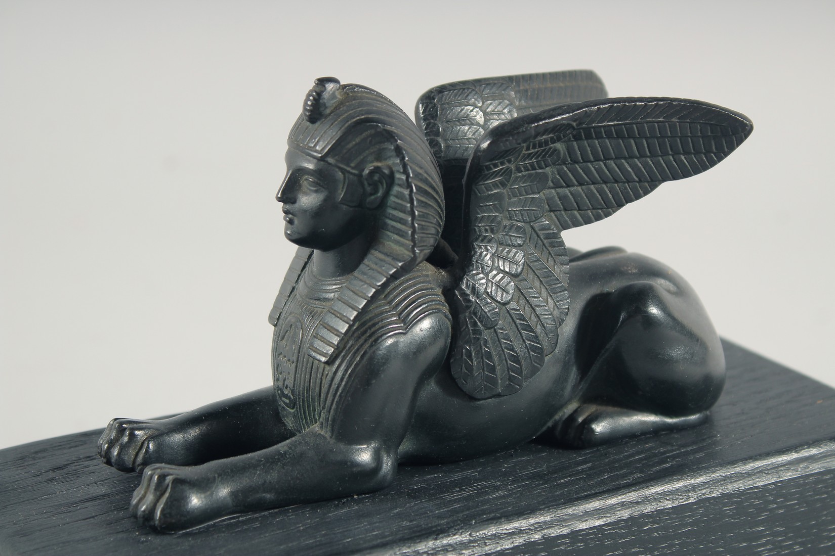 AN EGYPTIAN BRONZE SPHYNX, 6ins long on a wooden base. - Image 4 of 4