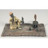 A VIENNA PAINTED COLD CAST BRONZE GROUP, amulet vendor standing on Persian rug. 5.5ins high.
