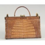 A 1940's - 1950's LARGE BROWN TWO COLOUR CROCODILE SKIN HANDBAG, with brass mounts and locks, raised