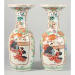A PAIR OF JAPANESE IMARI VASES with panels of figures and flowers. 18.5ins high.