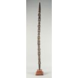 A LONG CARVED AND PAINTED WOODEN TRIBAL STAFF. 4ft long.