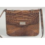 A 1940's - 1950's BROWN CROCODILE SKIN HANDBAG with chrome lock, fold over flap, fitted interior and