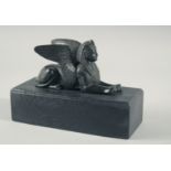 AN EGYPTIAN BRONZE SPHYNX, 6ins long on a wooden base.