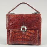 A 1940's - 1950's BROWN CROCODILE SKIN HANDBAG with chrome lock, fold over flap, leather and suede