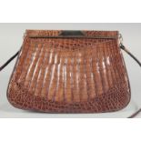 A 1930's - 1940's BROWN CROCODILE SKIN HANDBAG with gilt mount and suede fitted interior with long