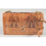 A 1940's - 1950's SNAKESKIN HANDBAG the skin showing two eyes with gilt mount, fold over front and