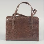 A 1940's - 1950's BROWN SNAKESKIN HANDBAG, folding interior with two snakeskin handles. 6.75ins