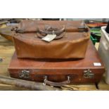 A leather doctors bag and a suitcase.