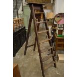 An old pair of Stephens and Carter wooden step ladders, broad arrow mark and G R ciphers.