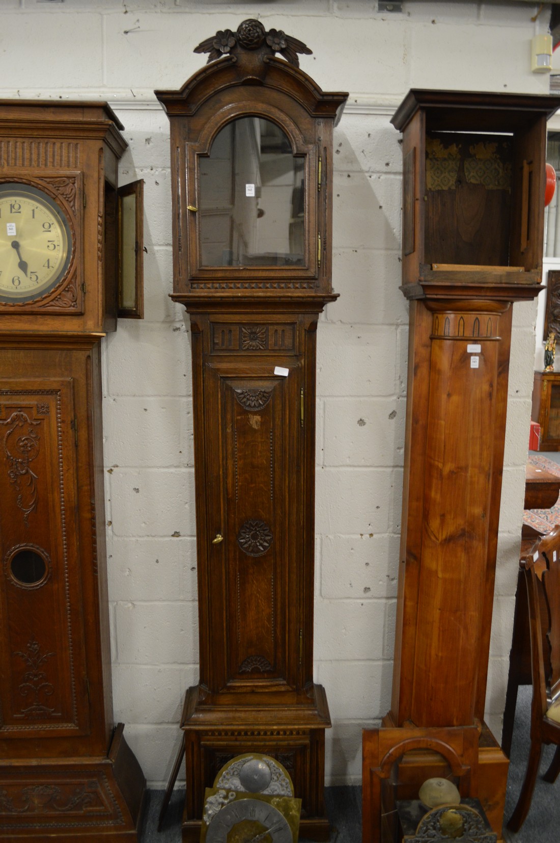 A Continental oak longcase clock, the movement with arched shaped dial.