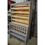 A grey painted pine trundle bedframe.