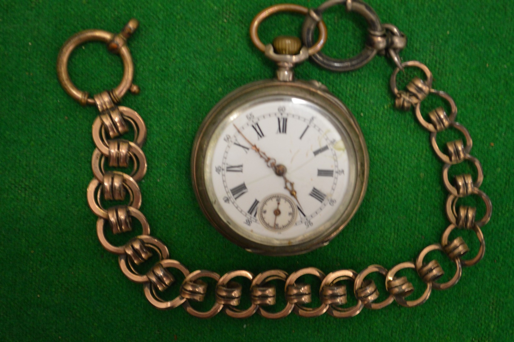 A pocket watch with gilt metal chain.