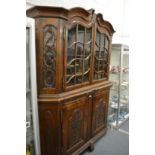 A large 19th century continental walnut two-part cabinet, the upper section with pair of glazed