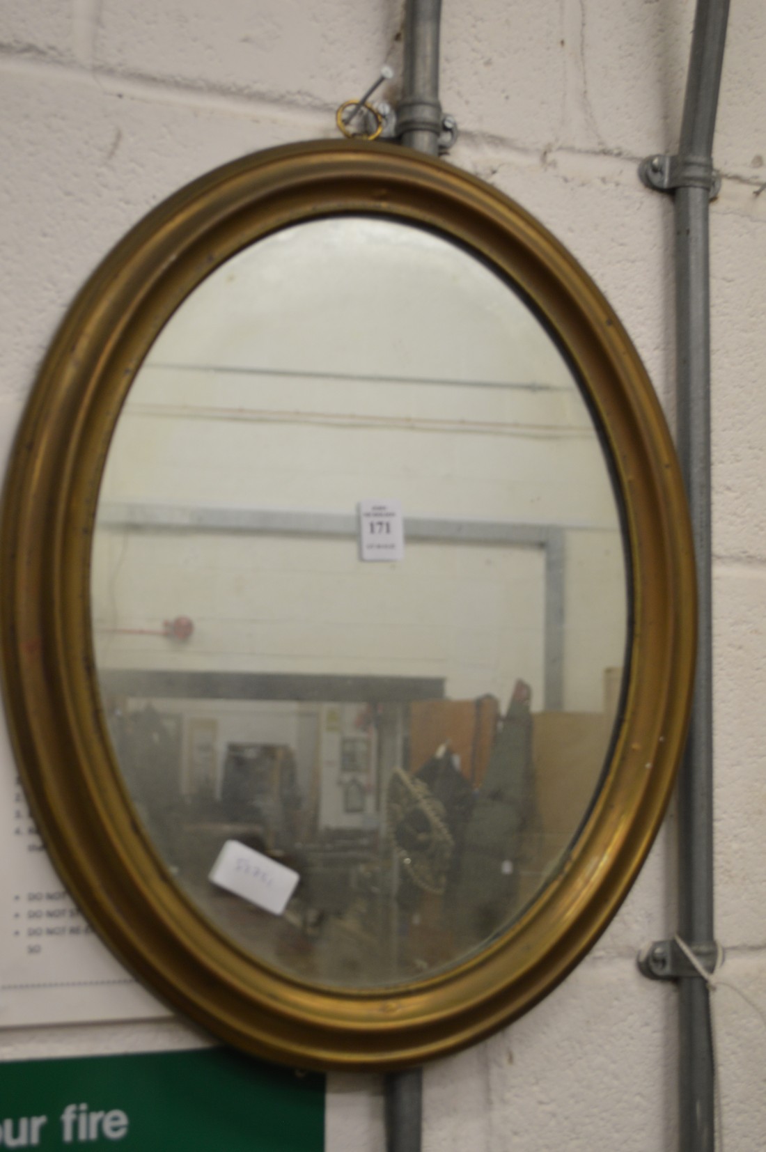 A brass framed oval mirror.