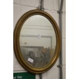 A brass framed oval mirror.