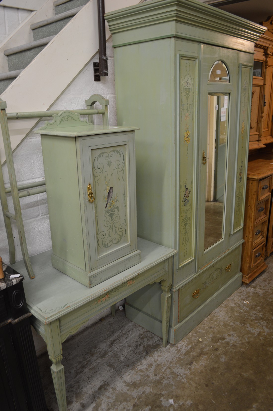 Decoratively painted part bedroom suite comprising wardrobe, pot cupboard, table, and towel rail.