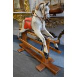 A grey painted rocking horse on pine base.