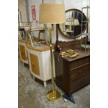 A brass floor standing adjustable lamp and pair of similar wall lights.
