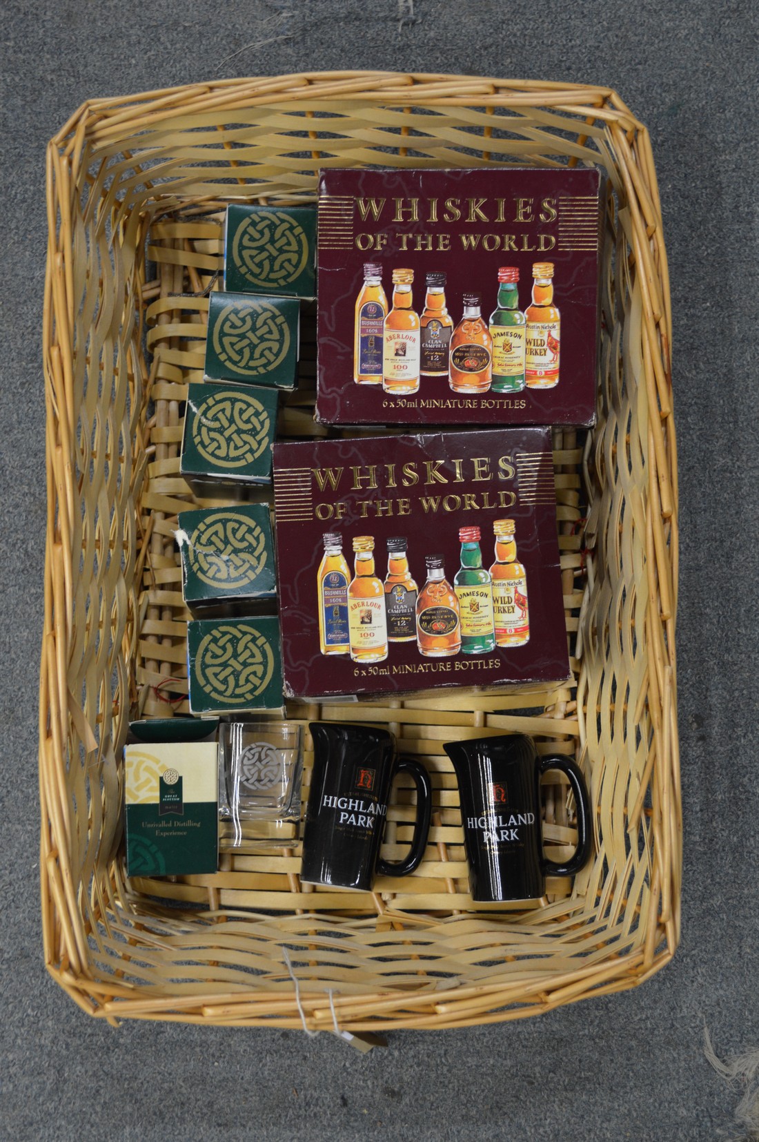 Two boxed sets of miniature whiskies together with shot glasses and miniature water jugs.