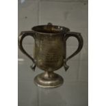 A silver three handled trophy cup.