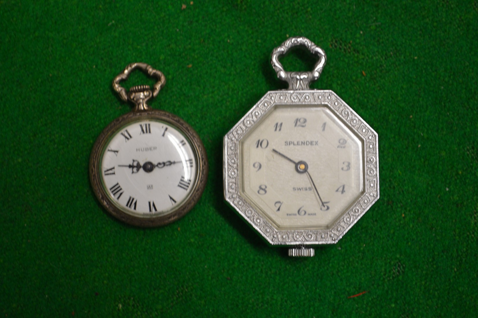 A miniature silver fob watch and another.