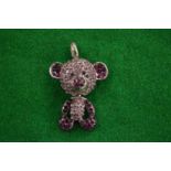 A teddy bear pendant.