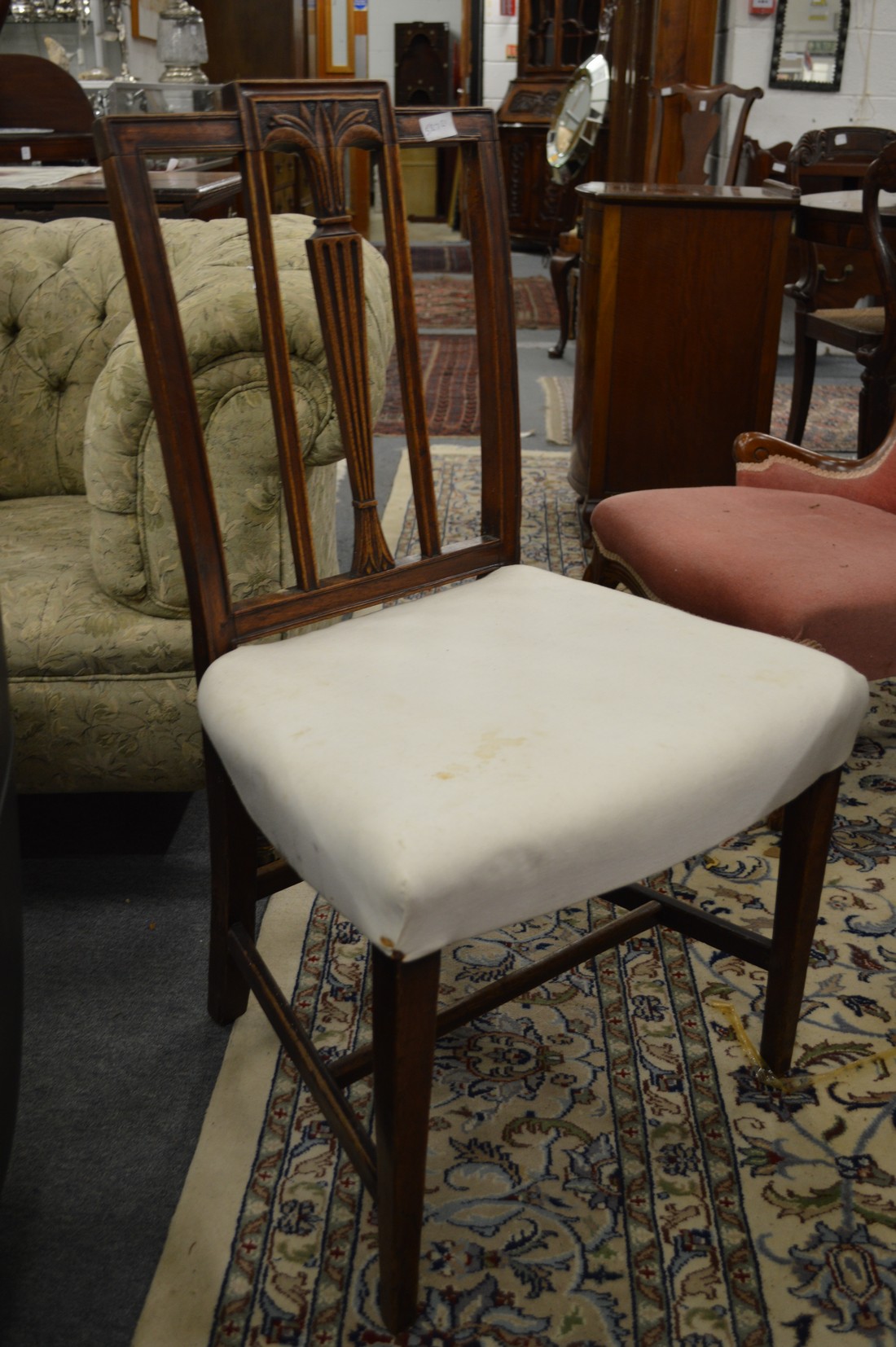 A set of six Edwardian mahogany dining chairs with cream upholstered overstuffed seats.