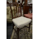 A set of six Edwardian mahogany dining chairs with cream upholstered overstuffed seats.